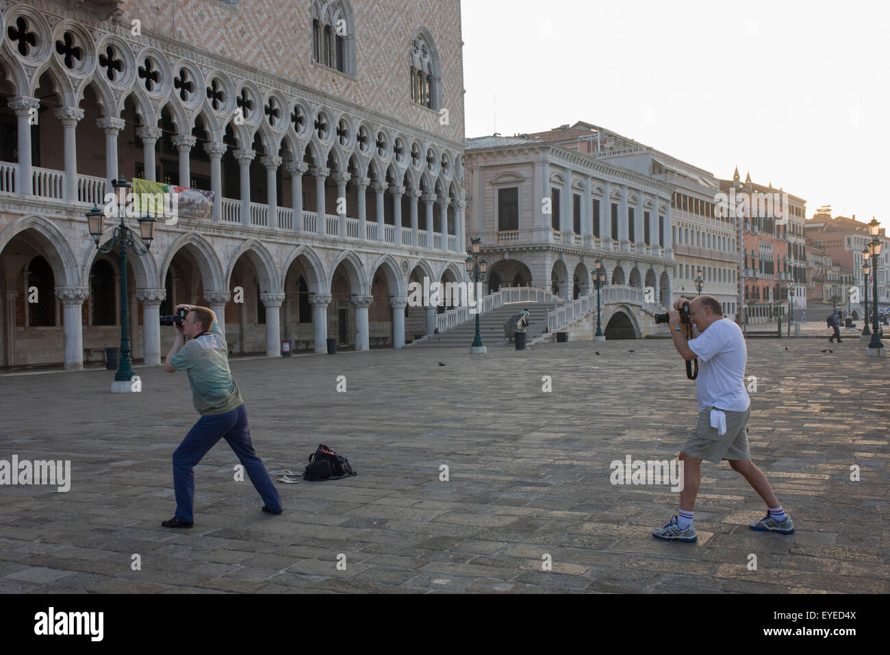 Fotografi piegare le ginocchia al di fuori del Palazzo Ducale in piazza San Marco, Venezia, Italia. Foto Stock