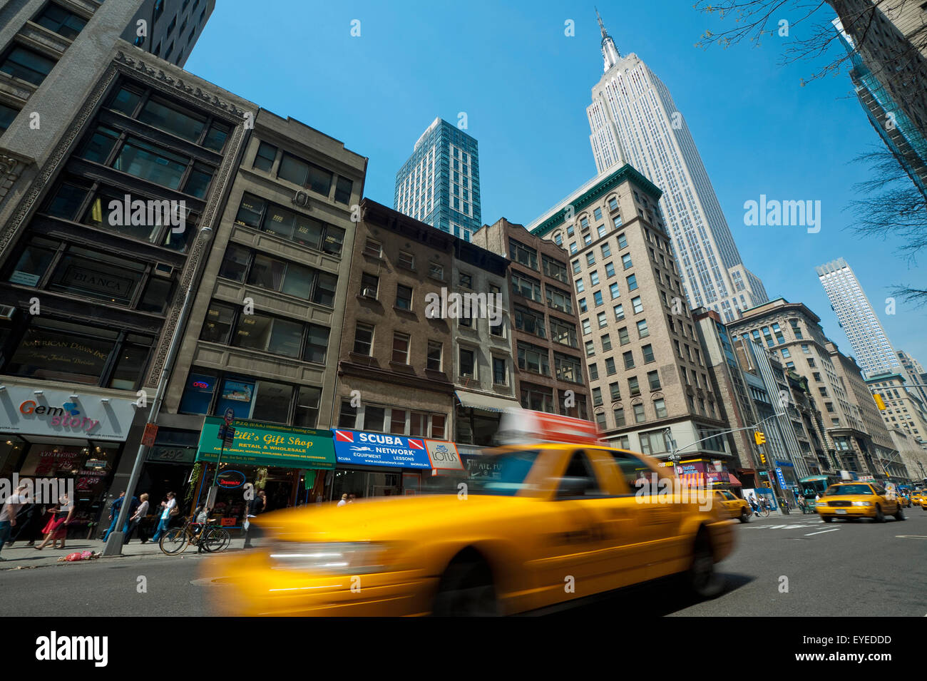 Taxi passano davanti all'Empire State Building, Manhattan, New York, Stati Uniti d'America Foto Stock