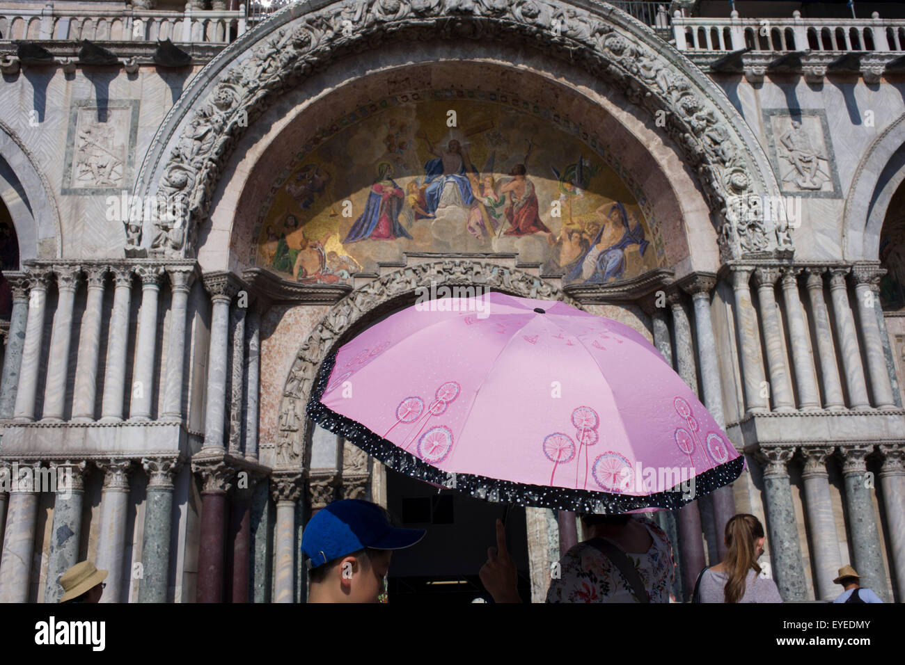 Turisti sotto l'ingresso alla Basilica di San Marco in Piazza San Marco, Venezia, Italia Foto Stock