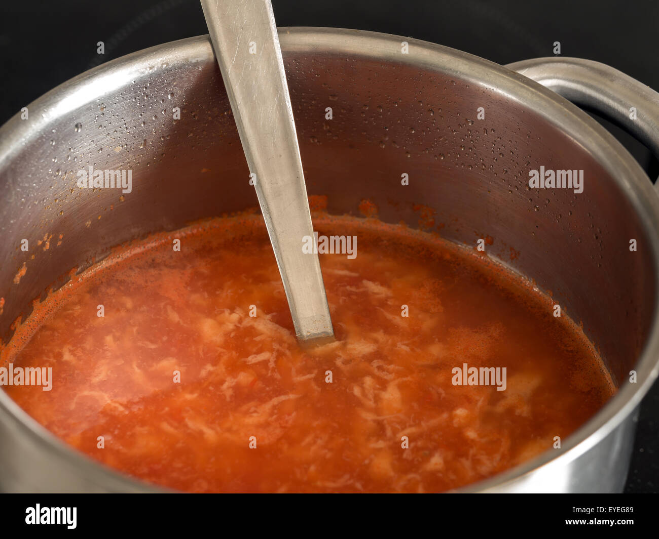 Zuppa di pomodoro con gnocchetti di pastella nella padella di metallo con bilanciere Foto Stock