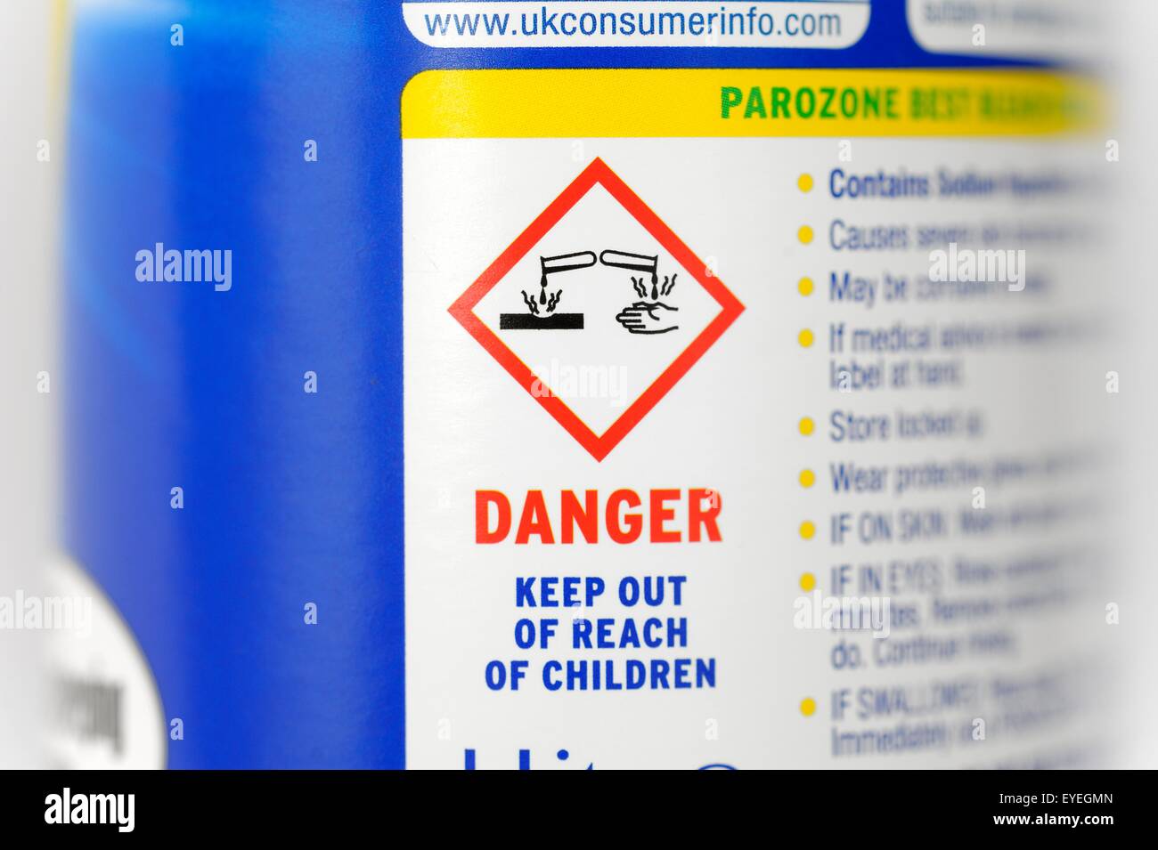 Caustico e simbolo di avvertimento su una bottiglia di candeggina Foto Stock