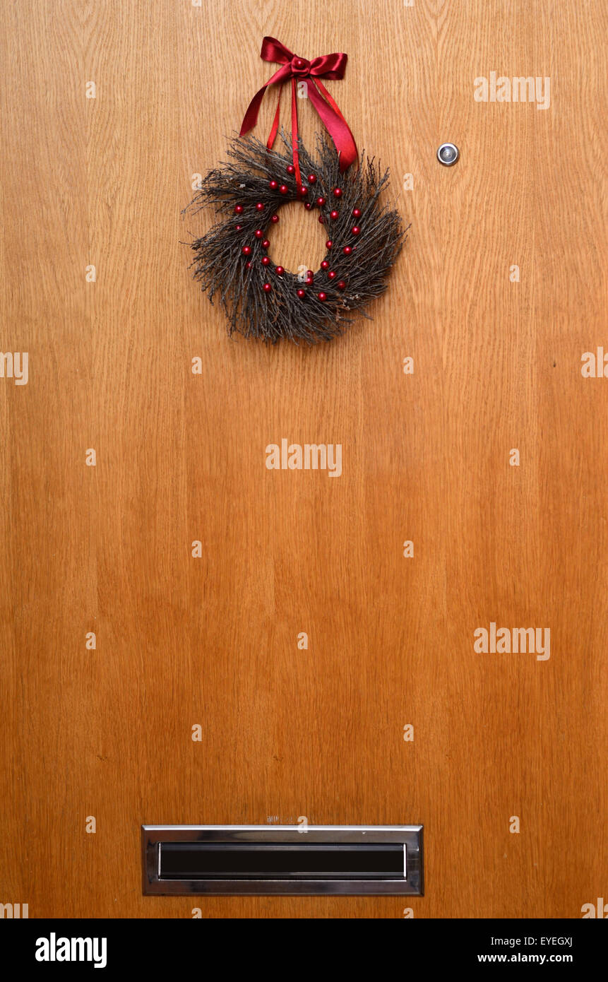 Porta di legno con una ghirlanda di Natale, occhio magico e casella vocale Foto Stock