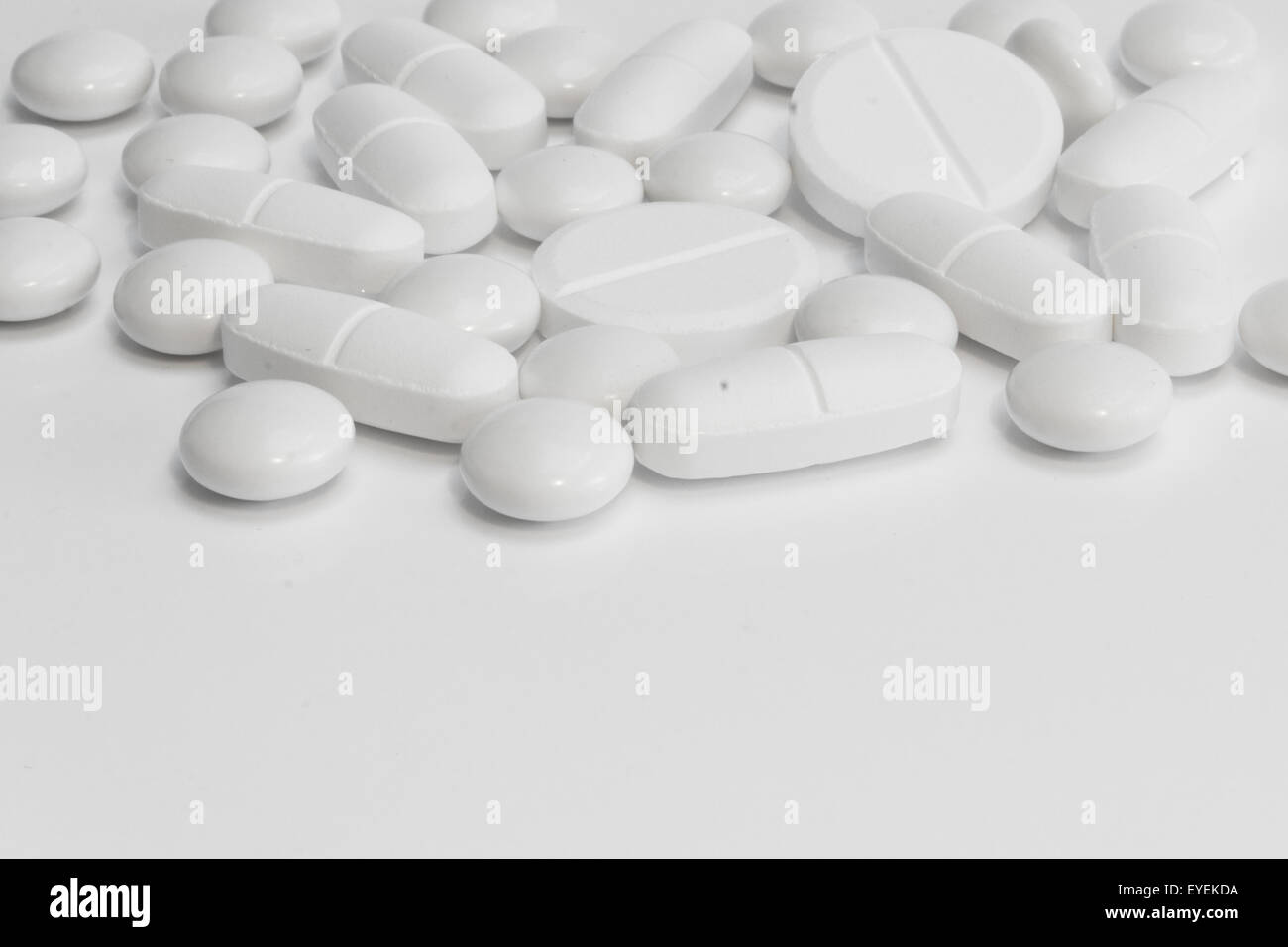 Molte pillole bianco / compresse su sfondo bianco Foto Stock