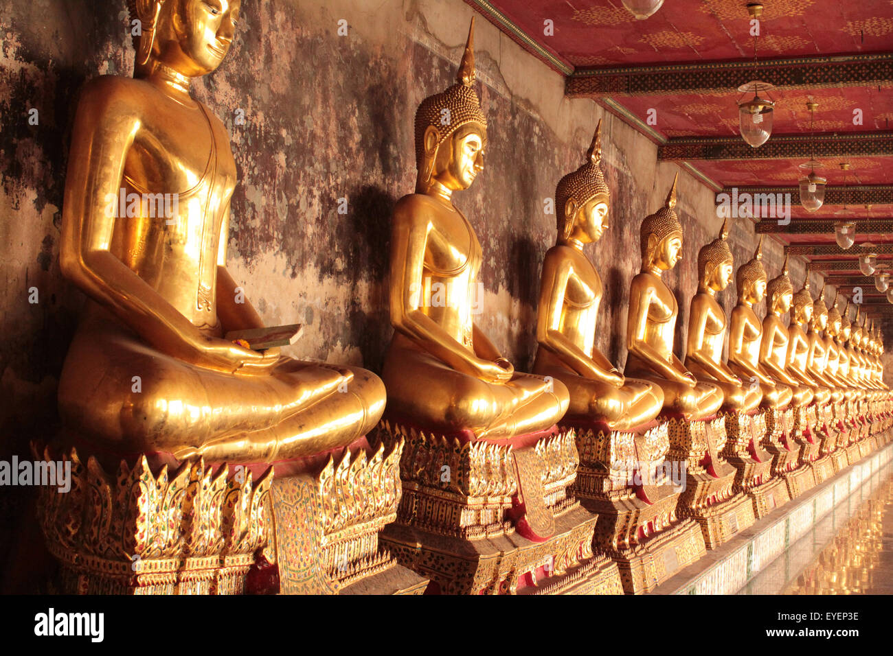 Golden Statue di Buddha in una riga , tempio buddista di Bangkok in Thailandia Foto Stock