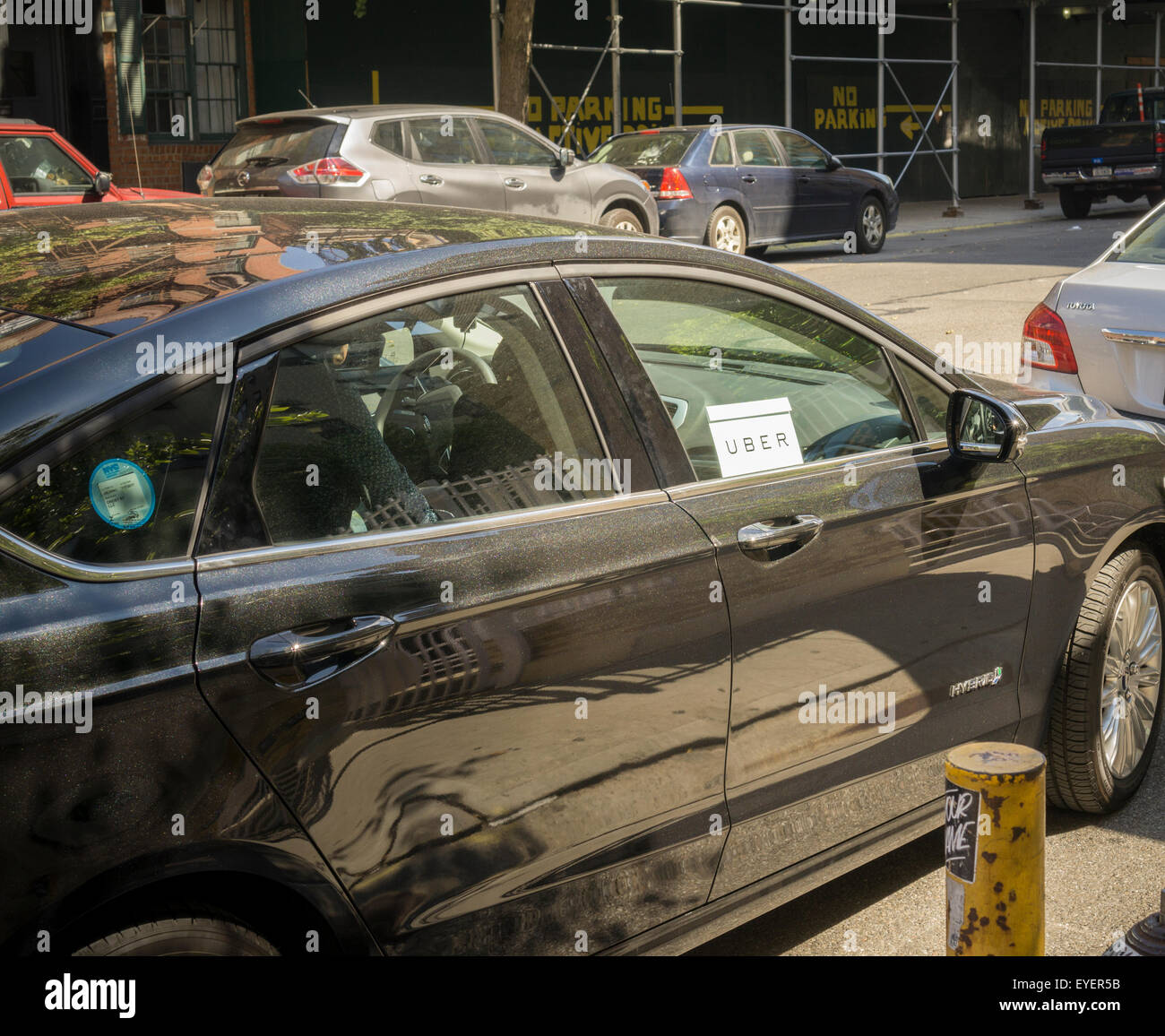 Un Uber livrea attende la loro passeggero in Greenwich Village di New York il mercoledì 22 luglio, 2015. La città di New York voto del Consiglio sul capping la quantità di livrea Uber auto è stata rinviata dopo che un accordo è stato realizzato per la Uber per fornire ulteriori informazioni e dati. (© Richard B. Levine) Foto Stock