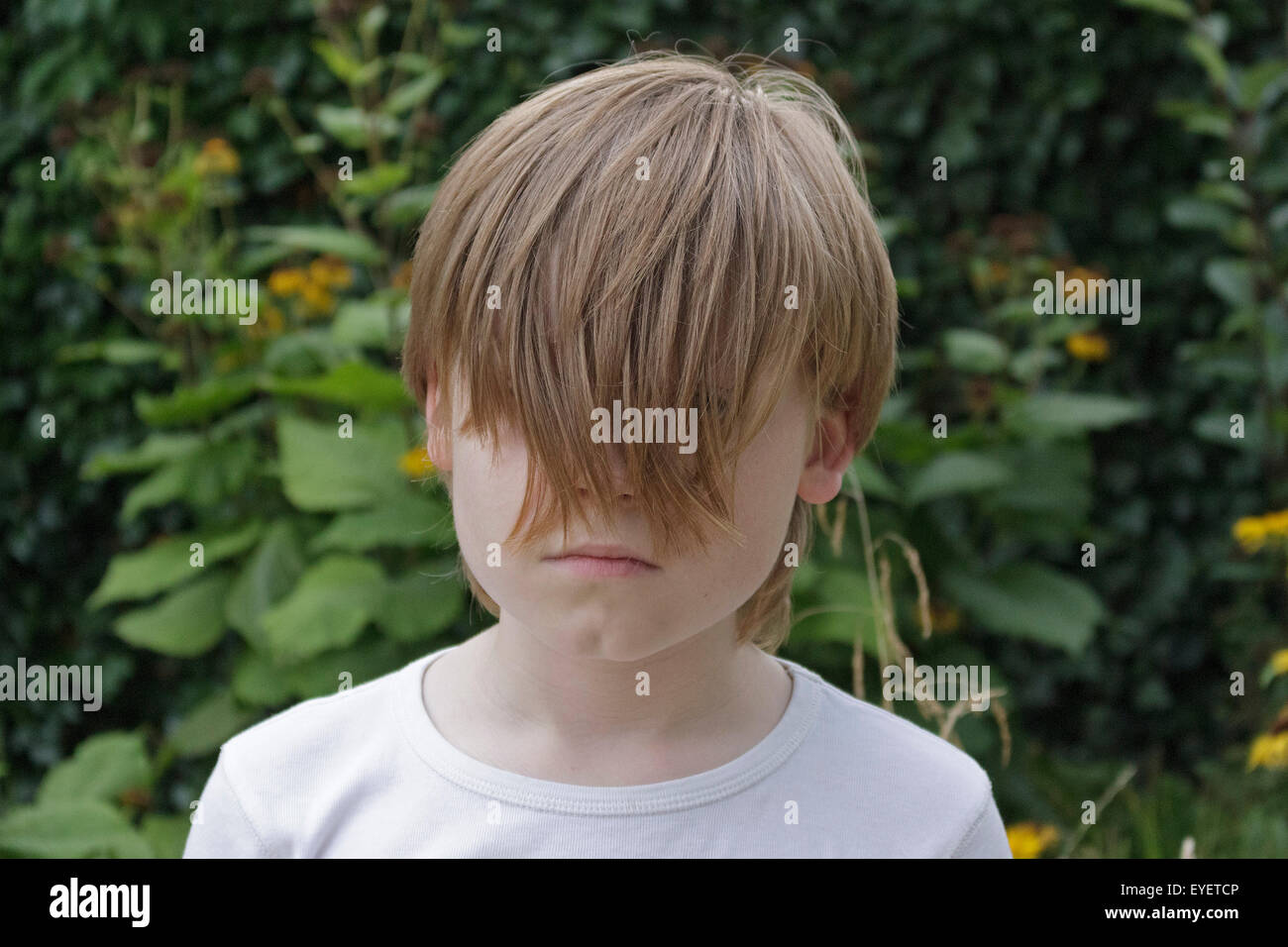 Ritratto di un giovane ragazzo con i suoi capelli che copre la sua gli occhi Foto Stock