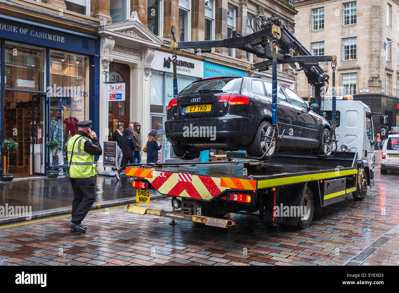 Vigile che autorizza la rimozione di un'auto parcheggiata, Glasgow, Scotland, Regno Unito Foto Stock