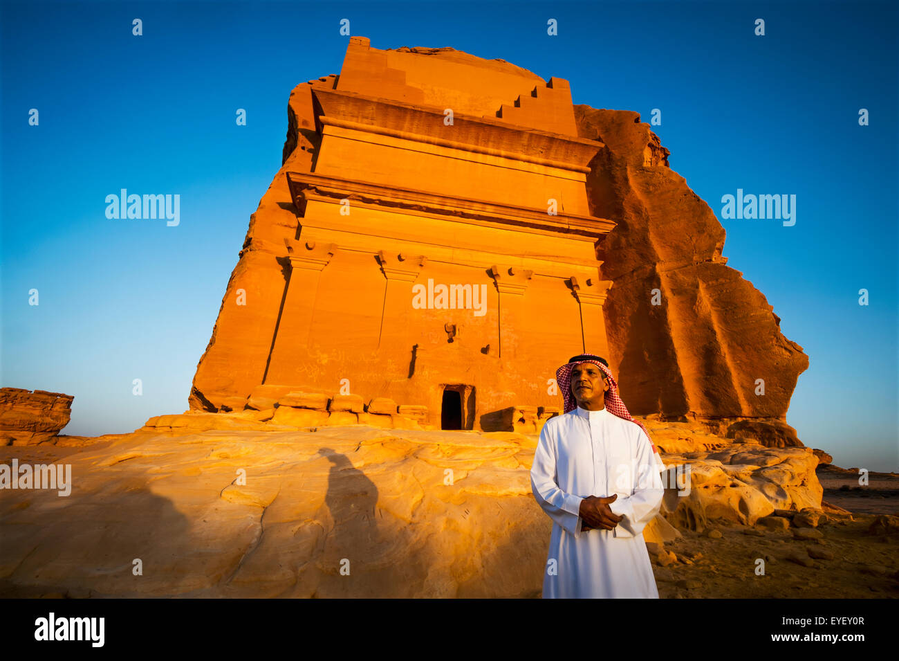 Un uomo si erge al di fuori di un rock-cut edificio; Medain Saleh, Arabia Saudita Foto Stock