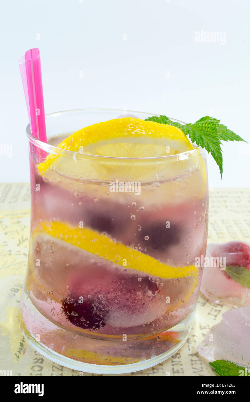 In casa naturale foresta rossa ghiacciata di frutta-T succo con ghiaccio, limone e frutta a fette Foto Stock