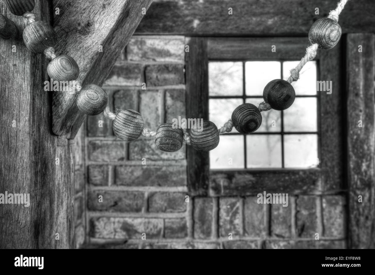 Immagine in bianco e nero di un rosario di legno in una piccola cappella Foto Stock