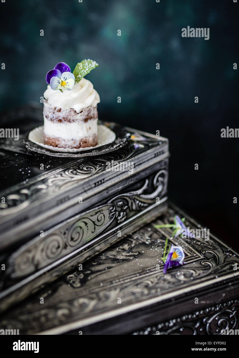 Piccola torta decorata con freschi fiori viola. Messa a fuoco selettiva. Foto Stock