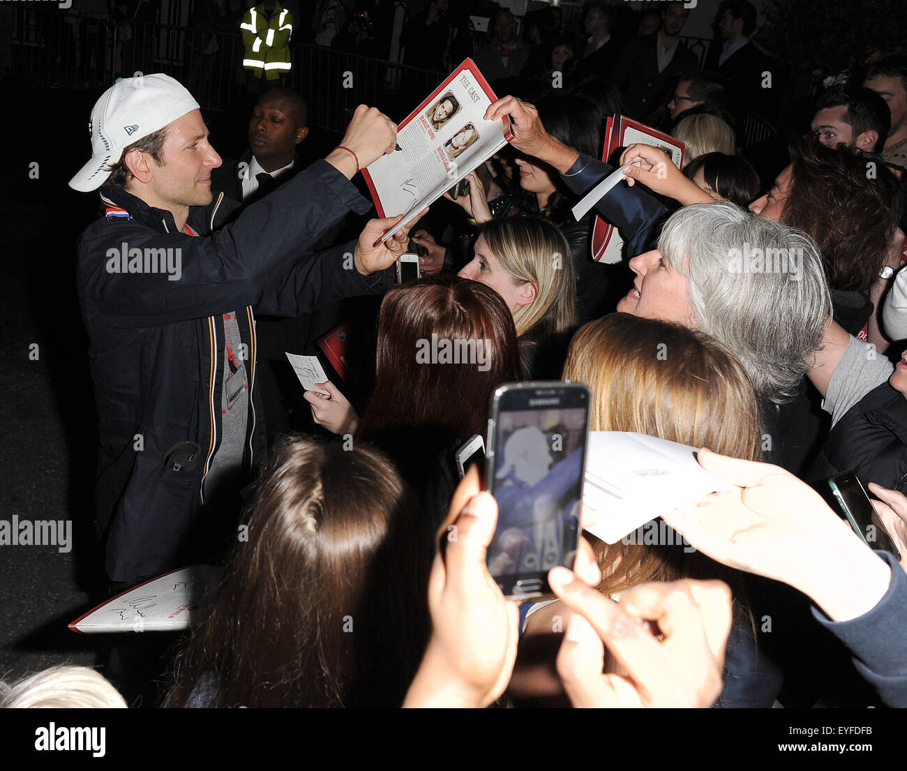 Bradley Cooper prende le foto con ventole, come egli lascia il teatro Royal Haymarket, avendo eseguito in una produzione di 'L'Elephant Man". Egli è stato indossando un cappello da baseball da anteriore a posteriore e una felpa con lo slogan "Città dell'amore fraterno" con: Bradley Cooper dove: Londra, Regno Unito quando: 27 maggio 2015 C Foto Stock
