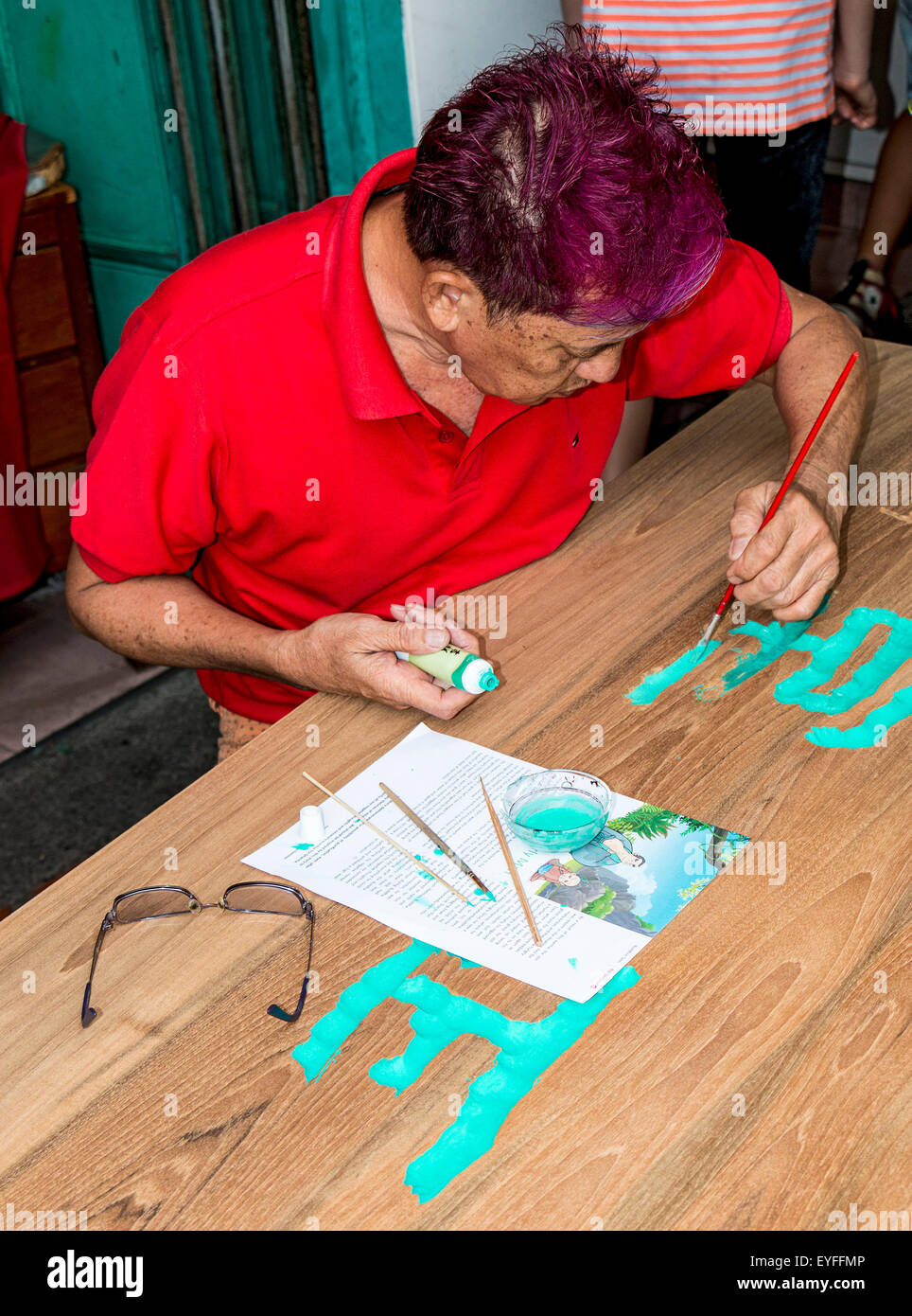 Proprietario del negozio a Singapore il quartiere Chinatown dipinge un nuovo segno per il suo negozio. Foto Stock