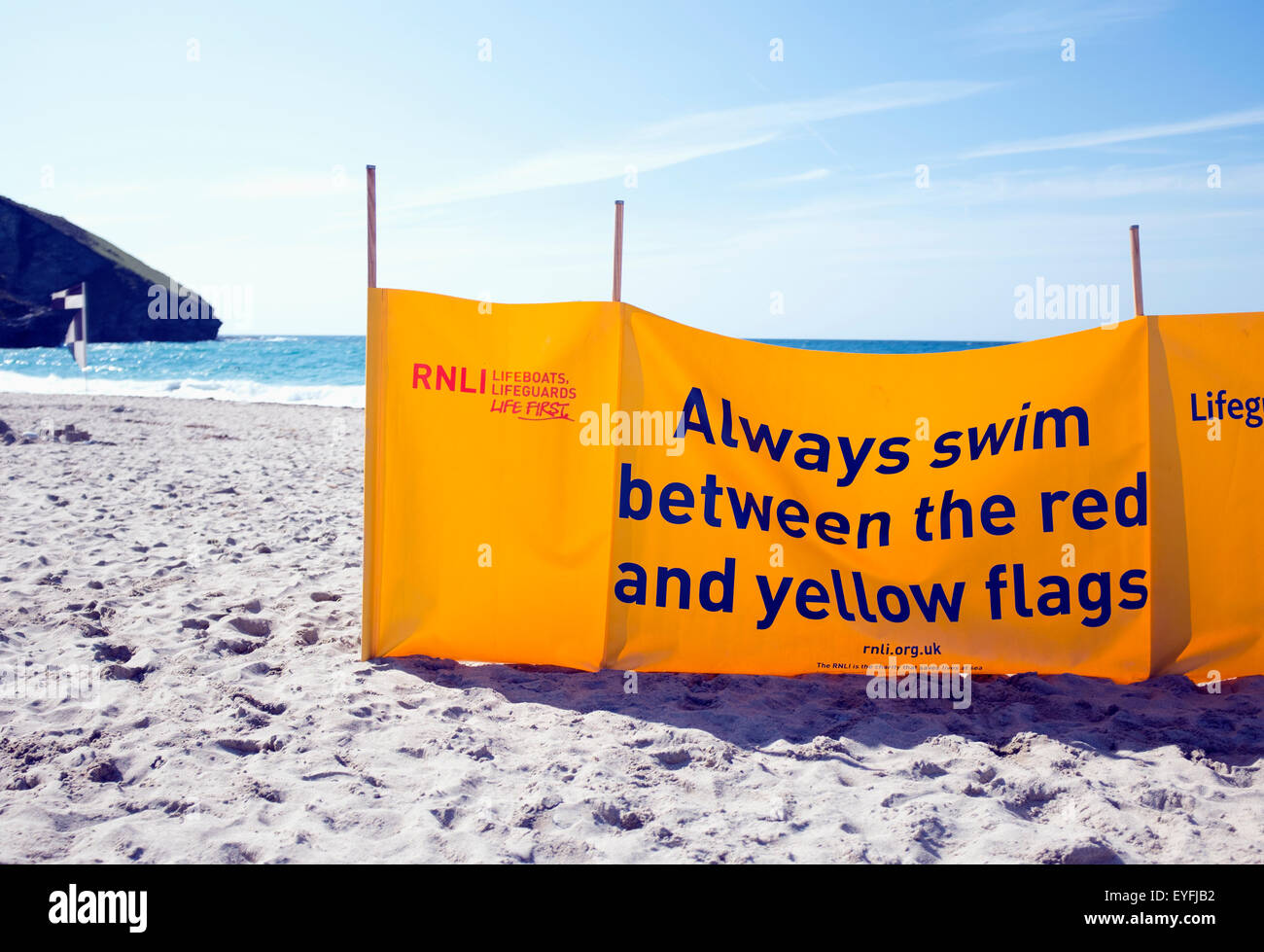 Giallo RNLI nuoto banner sulla spiaggia Portreath in Cornovaglia. Foto Stock