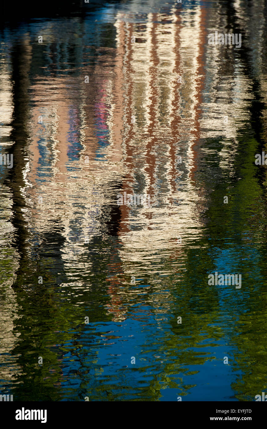 La riflessione di tradizionali case a capanna in canal; Amsterdam, Olanda Foto Stock