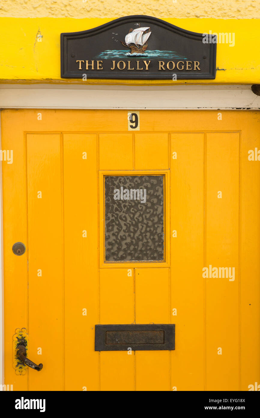 Regno Unito Galles, Gwynedd, Aberdovey, Copperhill Street, verniciato di colore arancione cottage porta con Jolly Roger segno Foto Stock