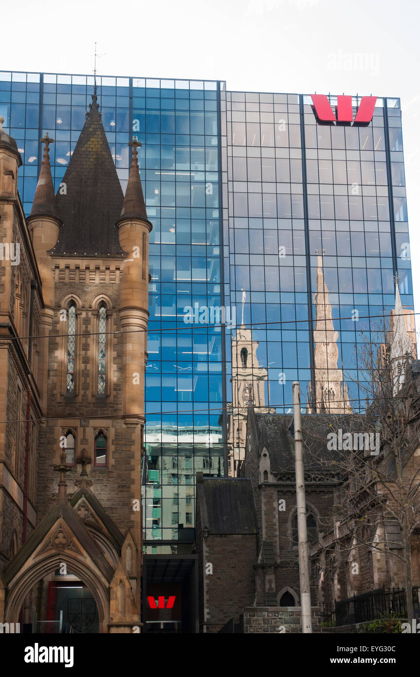Gotico vittoriano edifici chiesa riflessa in un ufficio aziendale dietro la torre di Collins Street, Melbourne, Australia Foto Stock