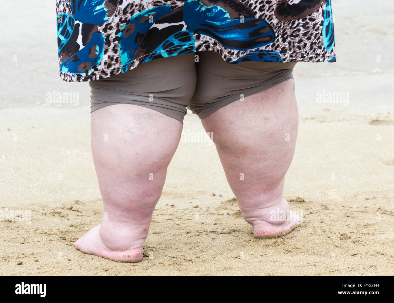 Donna obesa sulla spiaggia Foto Stock