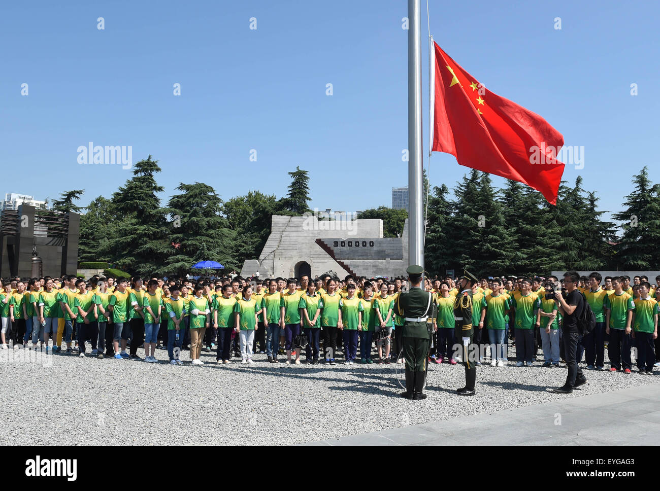 Nanjing, cinese della provincia di Jiangsu. 29 Luglio, 2015. Gli studenti frequentano una bandiera sollevamento cerimonia presso il Memorial Hall di vittime in Nanjing massacro da invasori giapponesi in Nanjing, a est della capitale cinese della provincia di Jiangsu, 29 luglio 2015. Circa 1200 studenti provenienti da cinese della provincia di Jiangsu, Hong Kong, Macao e Taiwan hanno visitato il Memorial Hall di mercoledì a commemorare le vittime uccise dall'esercito giapponese e anche in occasione del settantesimo anniversario della vittoria del popolo cinese la guerra di resistenza contro aggressioni giapponese e la seconda guerra mondiale. Credito: Sun può/Xinhua/Alamy Live News Foto Stock