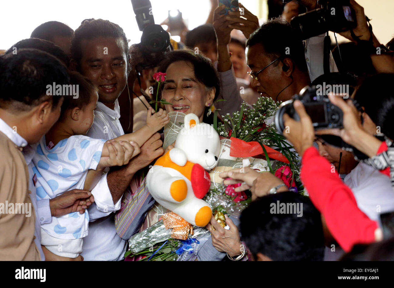 Yangon, Myanmar. 29 Luglio, 2015. Leader del Myanmar la Lega nazionale per la democrazia (NLD) di Aung San Suu Kyi (C) riceve fiori da un bambino dopo aver presentato la sua domanda per eseguire per la prossima multi-partito elezioni generali previste per il mese di novembre 8 a sud del distretto di Yangon commissione elettorale nella periferia di Yangon, Myanmar, luglio 29, 2015. Credito: U Aung/Xinhua/Alamy Live News Foto Stock