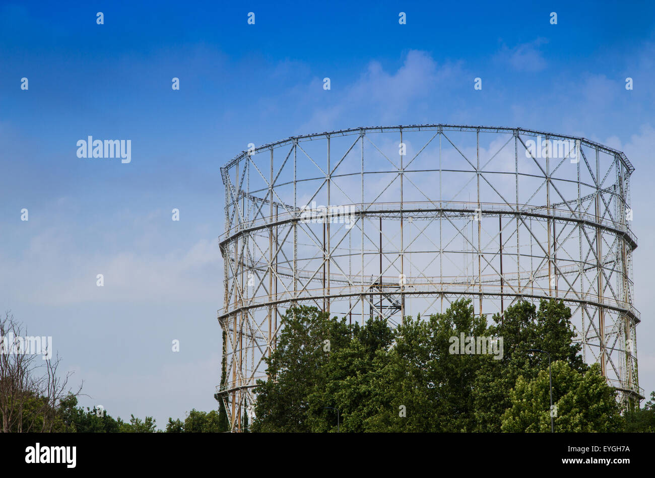 Vecchio gasometro in disuso metallo rivestito con vegetazione Foto Stock