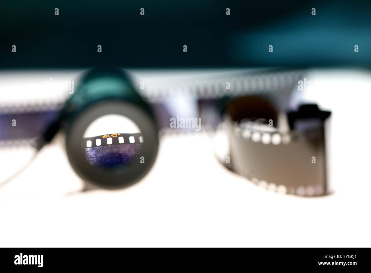 Un anello di fotografi e una pellicola di 35mm di spool su una scatola di luce Foto Stock