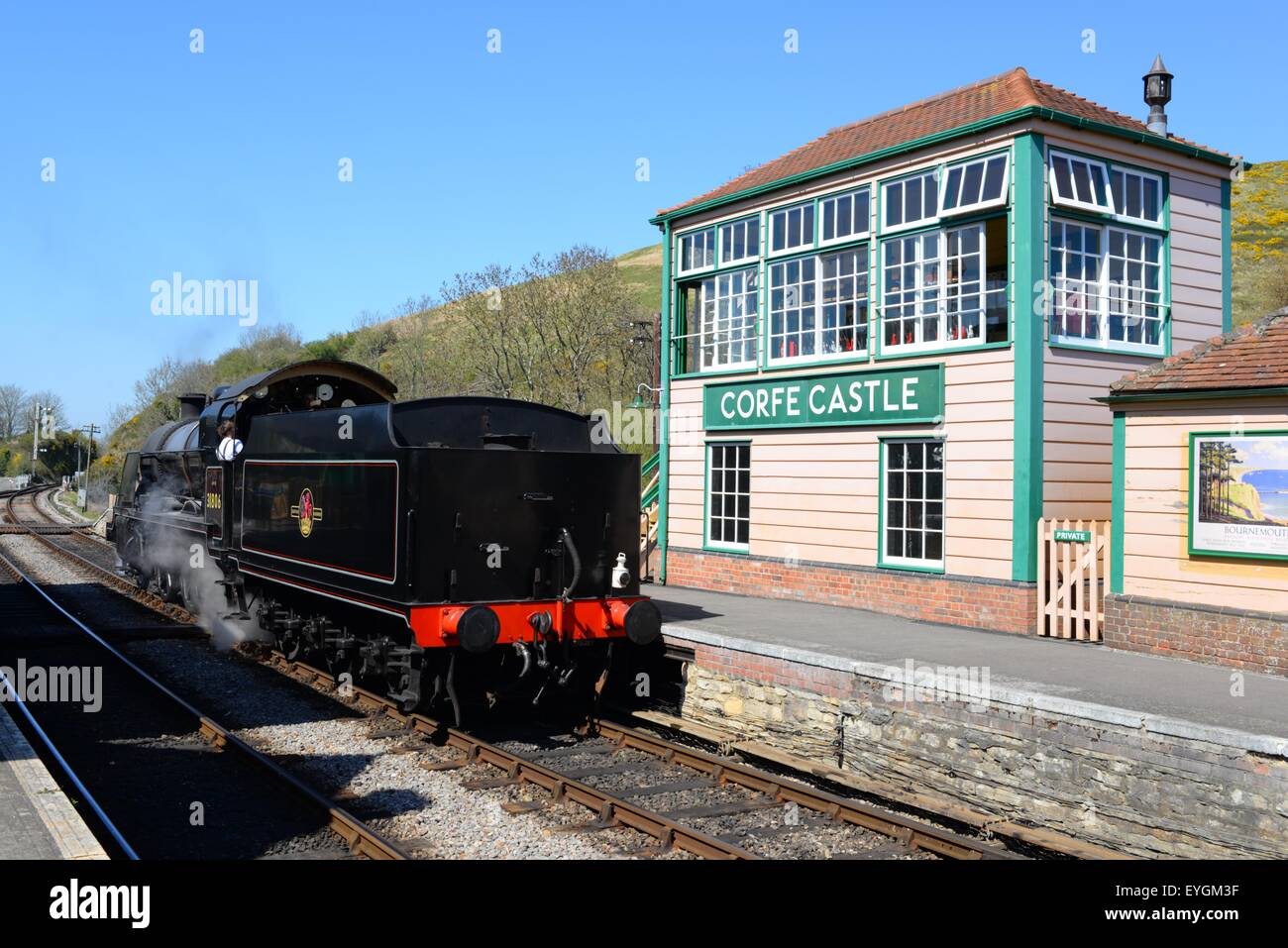 Corfe Caste stazione sulla Swanage Heritage Railway. Treno a flusso con scatola di segnale, Dorset, Regno Unito. Foto Stock