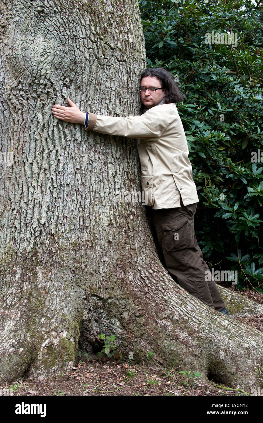L'uomo abbracci grande albero Foto Stock