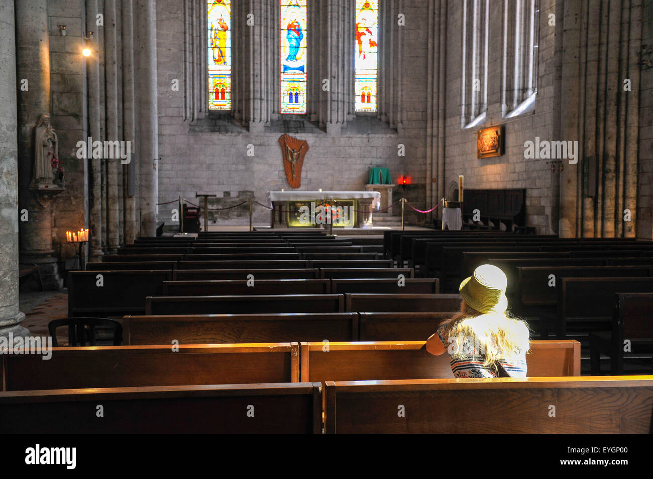 Una donna seduta sul banco nella chiesa abbaziale di Saint Pierre di Brantome Périgord Dordogne Aquitane Francia Foto Stock