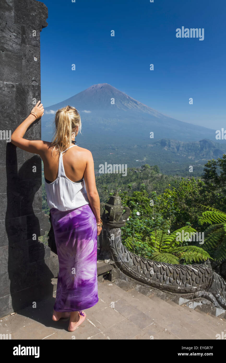 Indonesia, Bali, giovane donna in cerca di fronte al Monte Agung dal Tempio Lempuyang; Abang Foto Stock