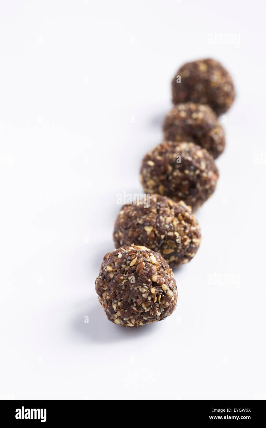 Cibi crudi. Data, le sementi e il dado morsi su una piastra bianca. Foto Stock