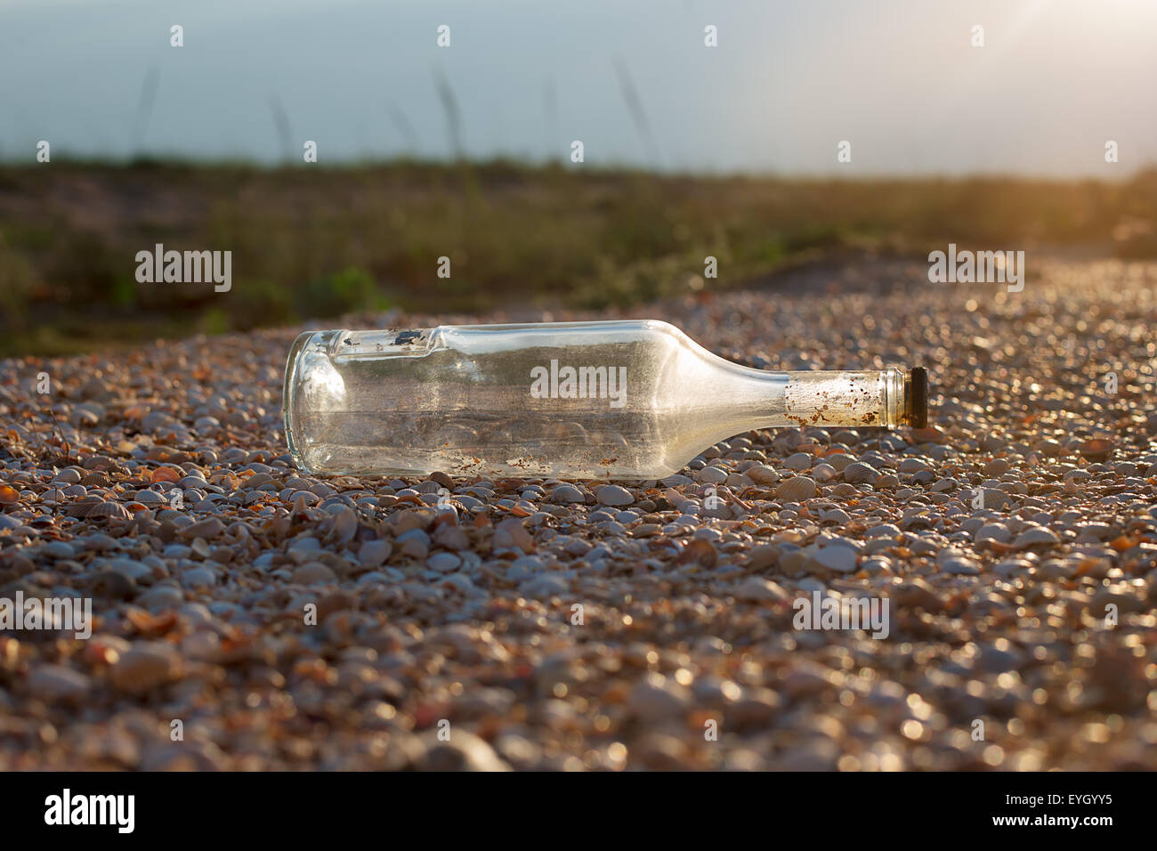 Vecchia bottiglia sigillata giacente su un guscio rock Foto Stock