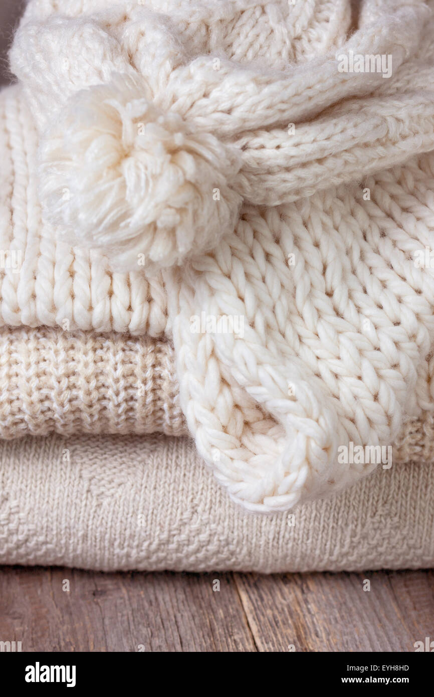 Pila di vestiti caldi sul vecchio sfondo di legno Foto Stock