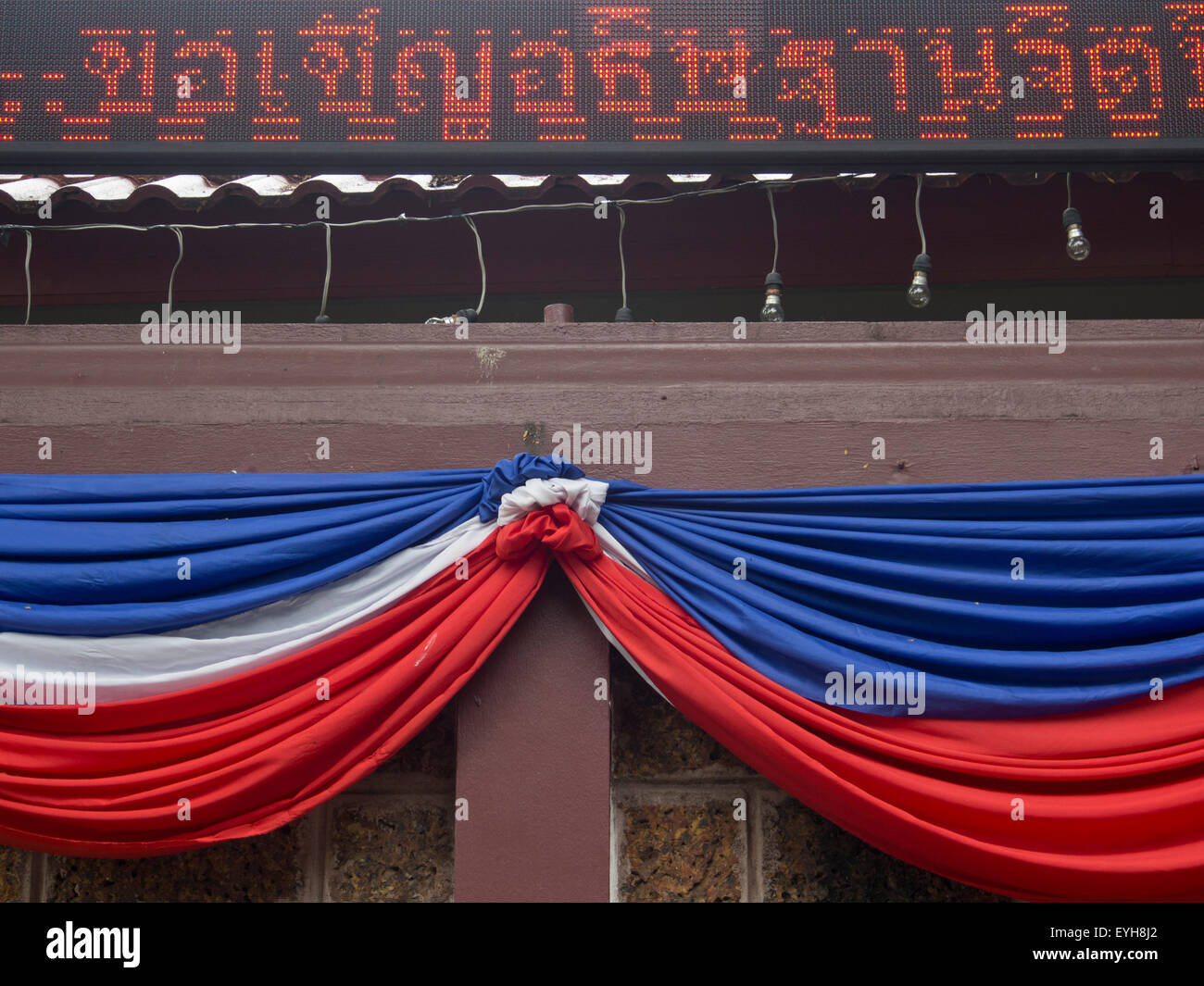 Bandiere nazionali e segno elettronico al di fuori di un tempio buddista in Chiang Mai Thailandia Foto Stock
