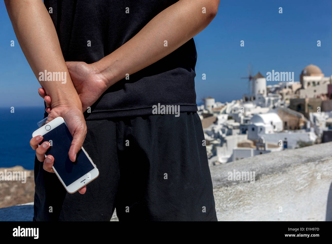 Uomo che tiene un telefono Oia Santorini turistico Grecia isola telefono cellulare turistico Foto Stock