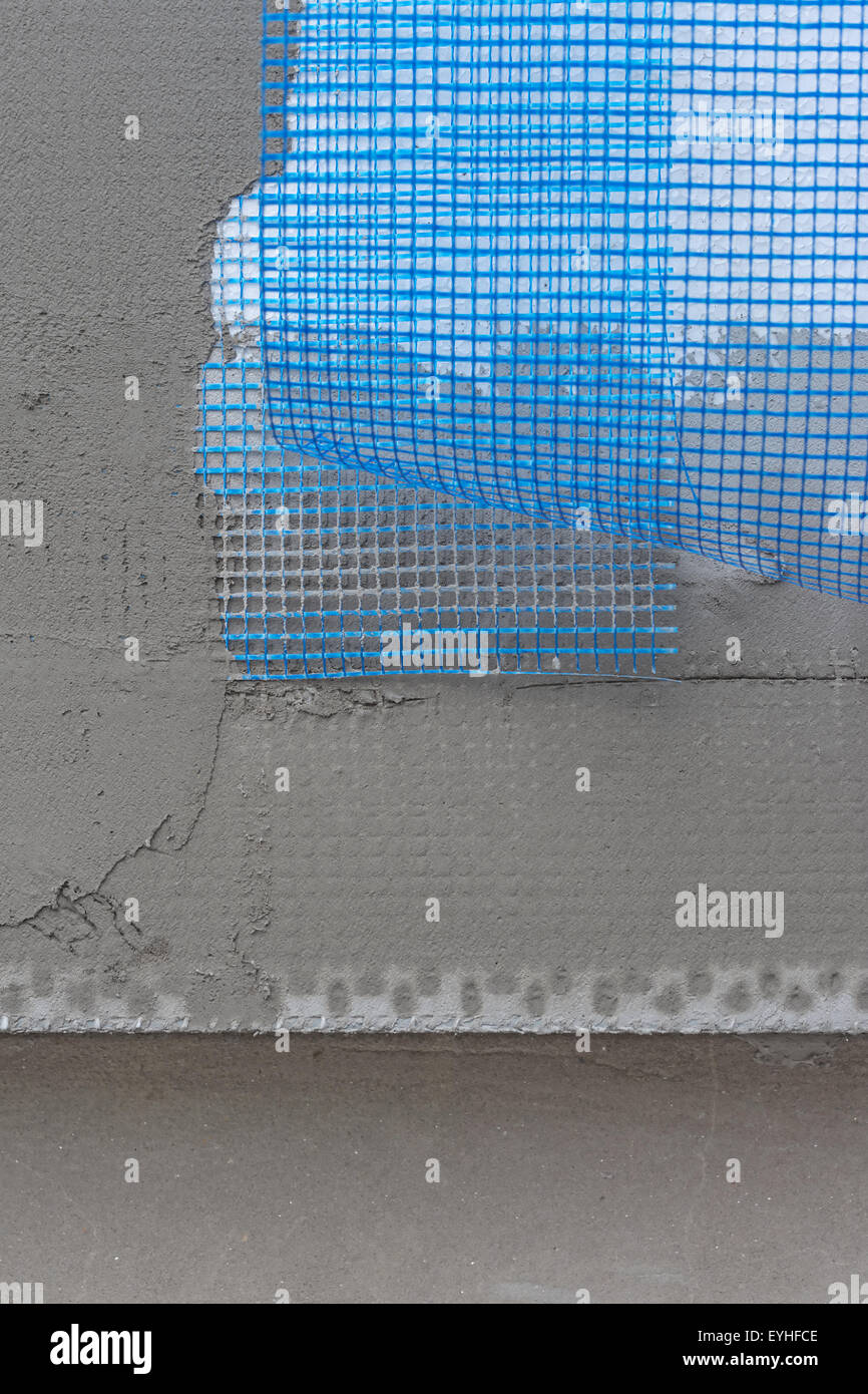 Isolamento in polistirene pannelli rivestiti con maglie di coperte e di mortaio sulla vecchia superficie di parete Foto Stock