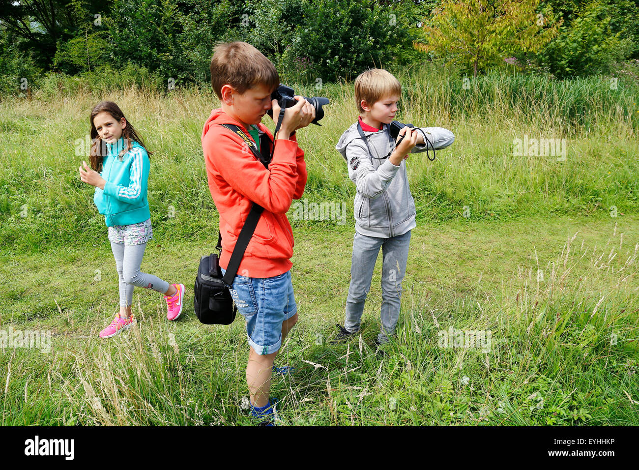 I bambini di scattare una foto su un grasshopper sul ragazzo del braccio Foto Stock