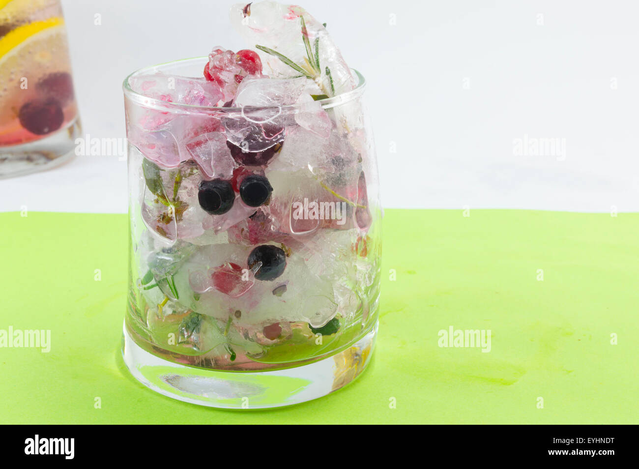 Naturale Foresta Rossa cocktail di frutta con ghiaccio, limone e frutta a fette in una storta di vetro, Estate drinkž Foto Stock