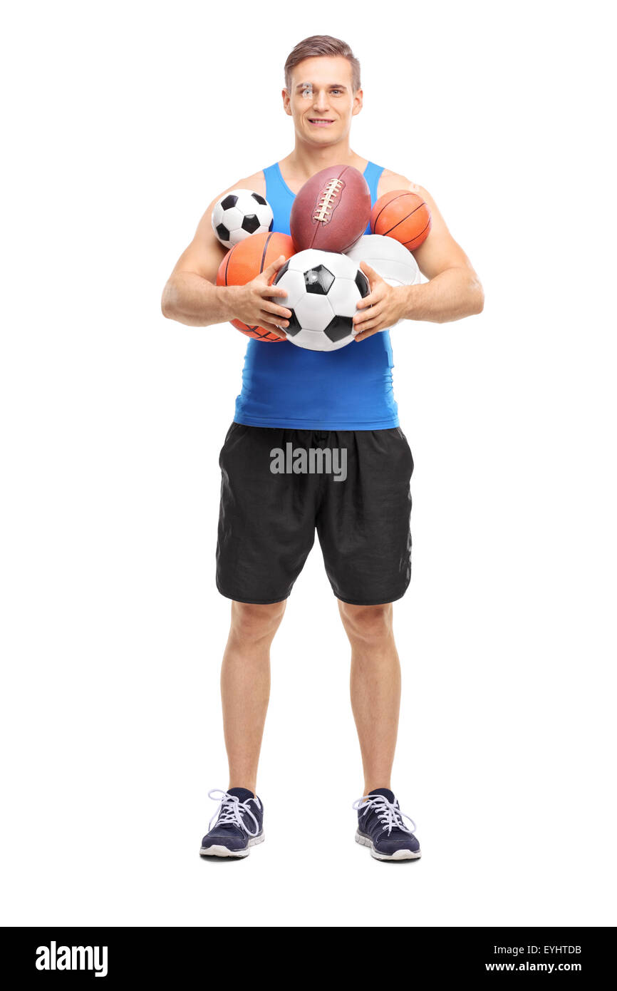 A piena lunghezza Ritratto di una giovane atleta tenendo un mazzetto di differenti tipi di palle sportive isolati su sfondo bianco Foto Stock