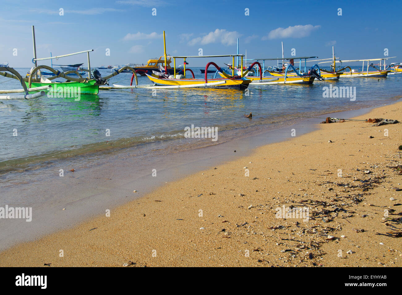 Imbarcazioni locali, chiamato jukungs, allineati al di ancoraggio su una spiaggia di Sanur, SE Bali, Indonesia Foto Stock