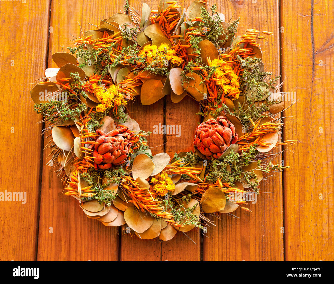 Ghirlanda di autunno con fiori secchi contro uno sfondo di legno Foto Stock
