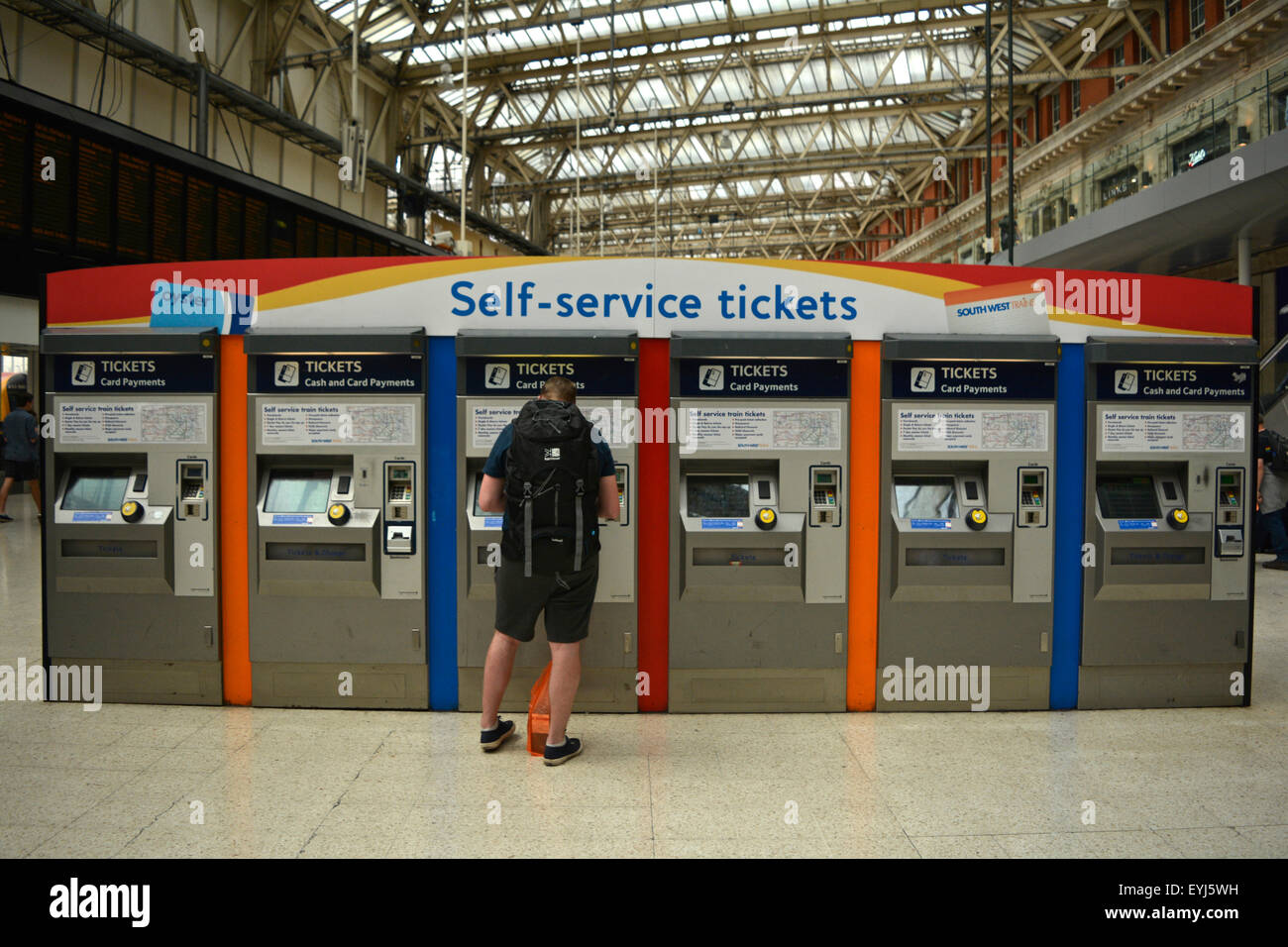 Vista del moderno atrio partenze con informazioni di rete schermate e distributori automatici di biglietti presso la stazione di Waterloo Foto Stock