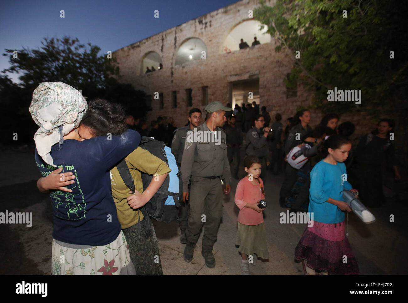 (150730) -- Gerusalemme, 30 luglio 2015 (Xinhua) -- coloni ebrei abbracciare ogni altra durante una evacuazione dei coloni dalle forze di sicurezza israeliane nella liquidazione del Sa-Nur in Cisgiordania settentrionale, il 30 luglio 2015. Forze di sicurezza israeliane giovedì evacuato circa 200 coloni provenienti dal sito di ex insediamento illegale della Sa-Nur in Cisgiordania settentrionale, un portavoce militare ha detto in una dichiarazione. Poiché Sa-Nur è stato evacuato come parte del 2005 il piano di disimpegno da Gaza, ex Sa-Nur residenti hanno fatto numerosi tentativi di ricostruire il loro insediamento. (Xinhua/JINI/Miri Tzachi Foto Stock