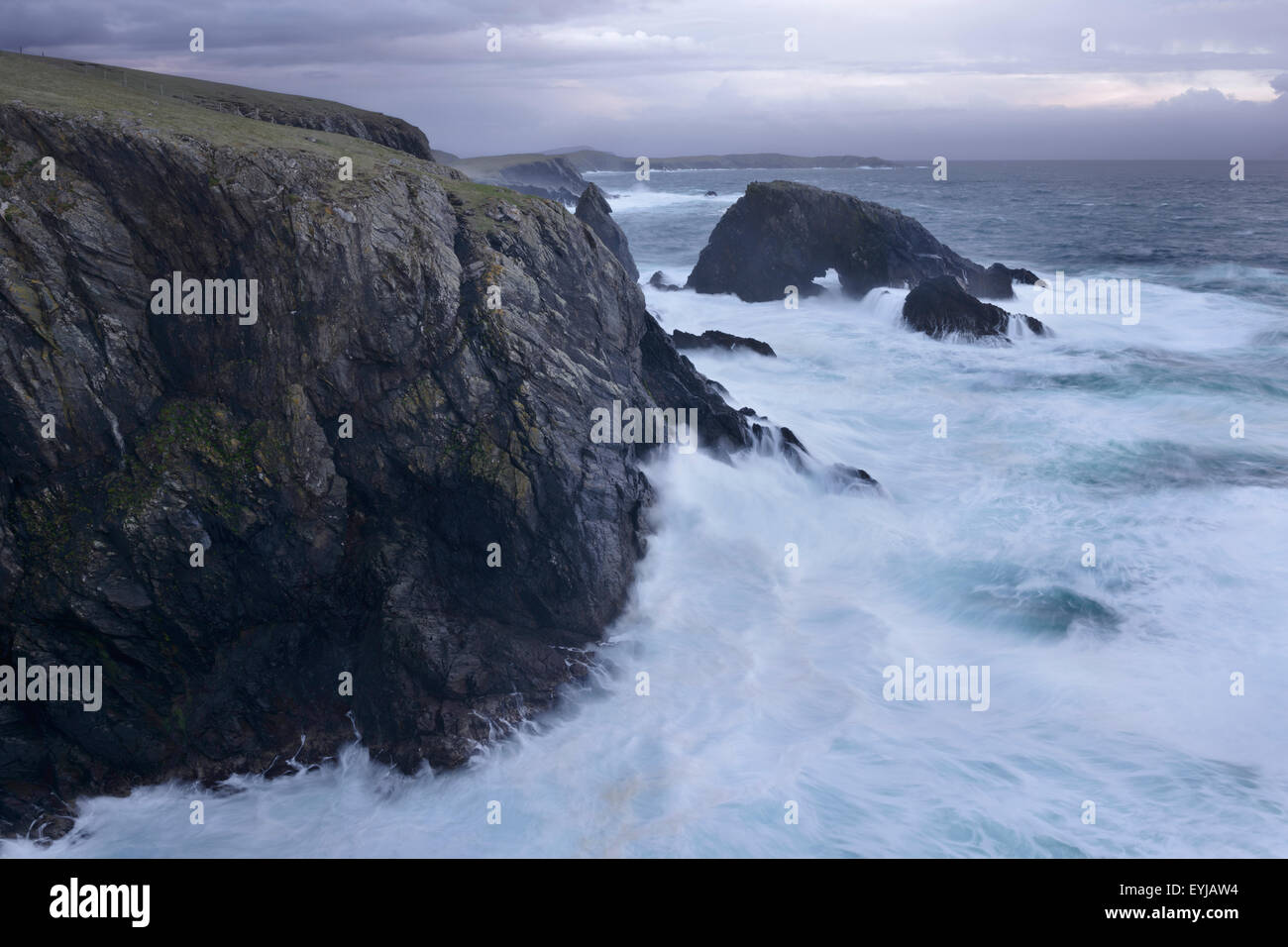 Un arco naturale essendo martoriata da onde vicino a stoppino di balena, West Burra, Shetland. Foto Stock