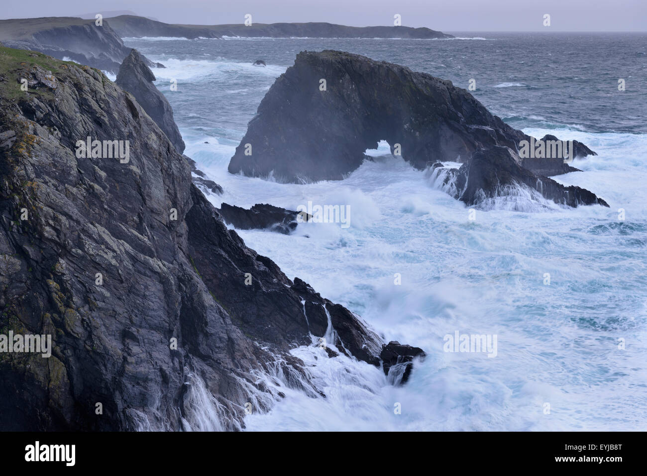 Un arco naturale essendo martoriata da onde vicino a stoppino di balena, West Burra, Shetland. Foto Stock