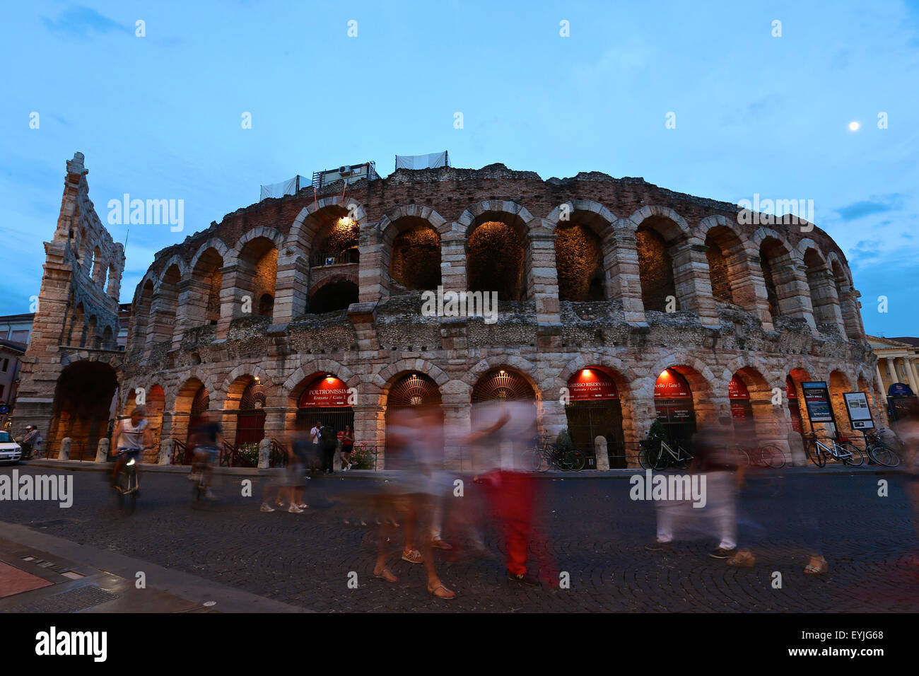 Verona. 26 Luglio, 2015. La gente a piedi passato l'Arena di Verona, 26 luglio 2015. Verona è una città nel nord Italia del Veneto. Come una delle principali destinazioni turistiche in nord Italia, la città ha patrimoni artistici, fiere annuali, spettacoli e opere liriche. Si è elencato come un patrimonio mondiale dell'UNESCO nel 2000 per i suoi edifici storici. © Jin Yu/Xinhua/Alamy Live News Foto Stock