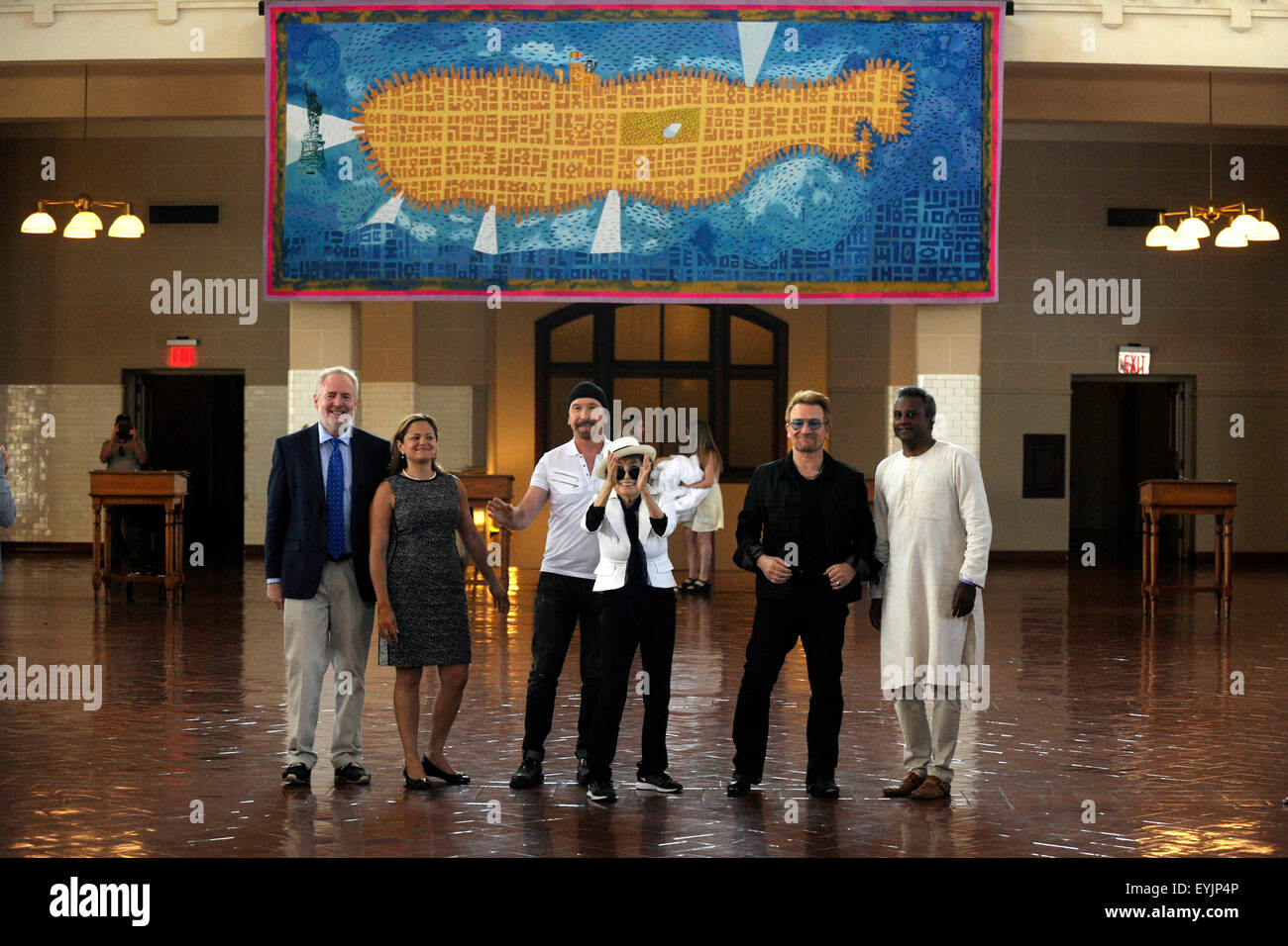 La città di New York. 29 Luglio, 2015. Altoparlante del New York City Council, Melissa Mark-Viverito, il bordo, Yoko Ono, Bono, e il segretario generale, Salil Shetty frequentare Amnesty International arazzo in onore di John Lennon scoprimento ad Ellis Island il 29 luglio 2015 in New York City./picture alliance © dpa/Alamy Live News Foto Stock