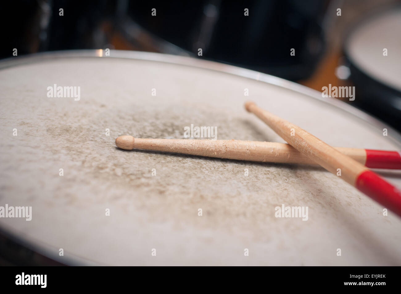 Paio di tamburo utilizzato bastoni dettaglio su un tom Foto Stock
