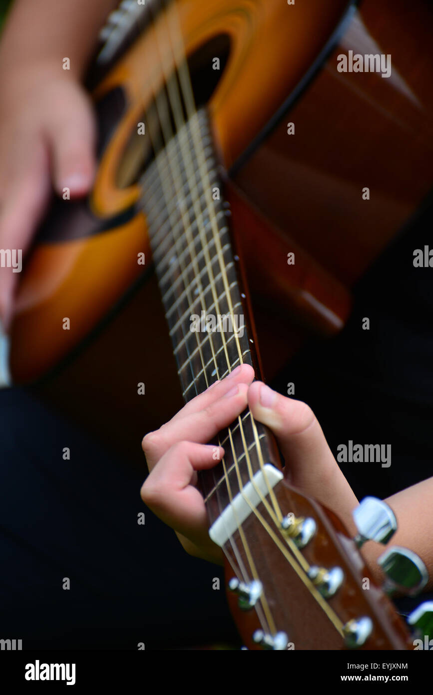 Dettaglio di una chitarra con una mano per bambini Foto Stock