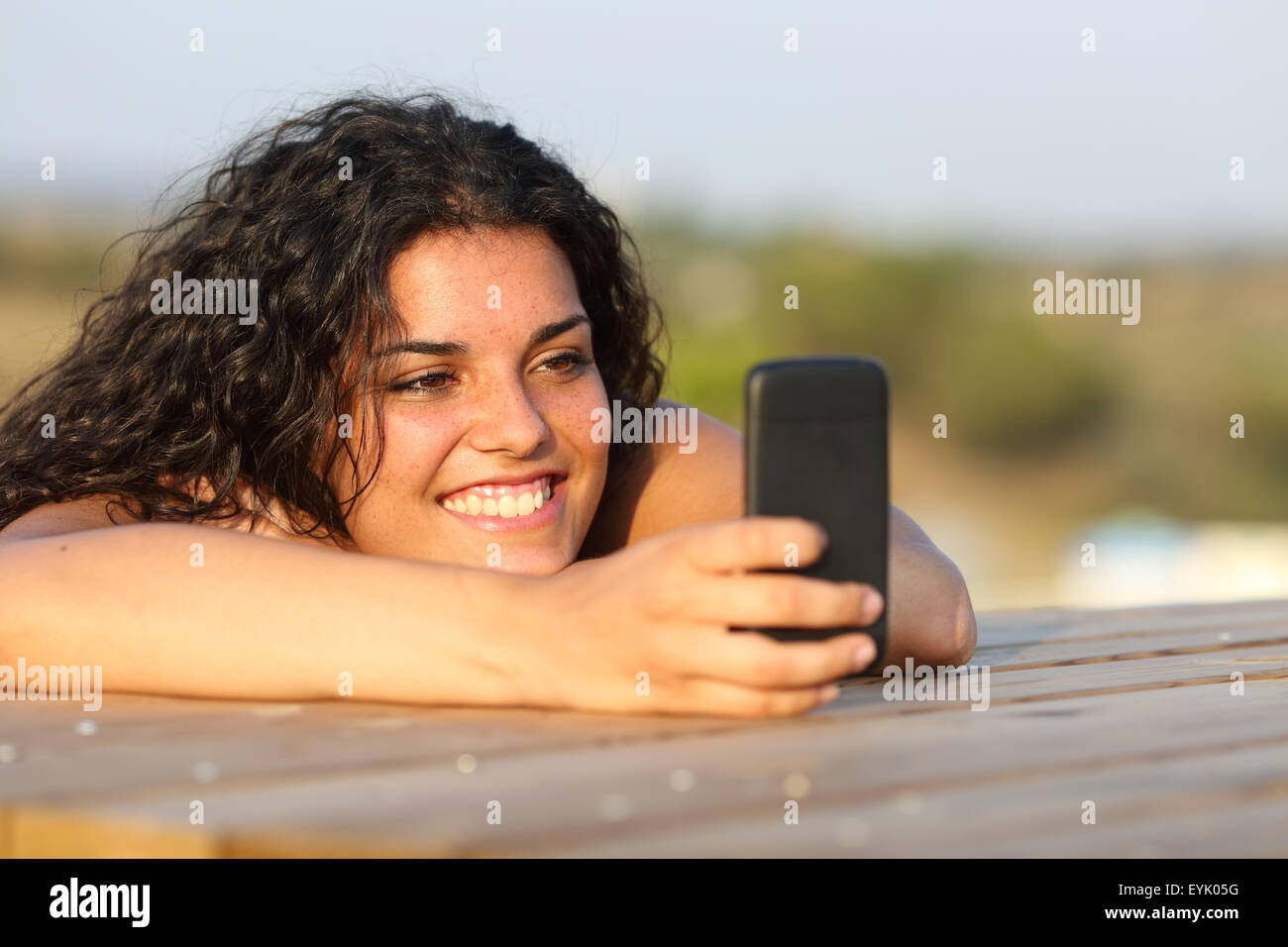 Funny Girl guardando i social media in smart phone rilassante in un parco Foto Stock